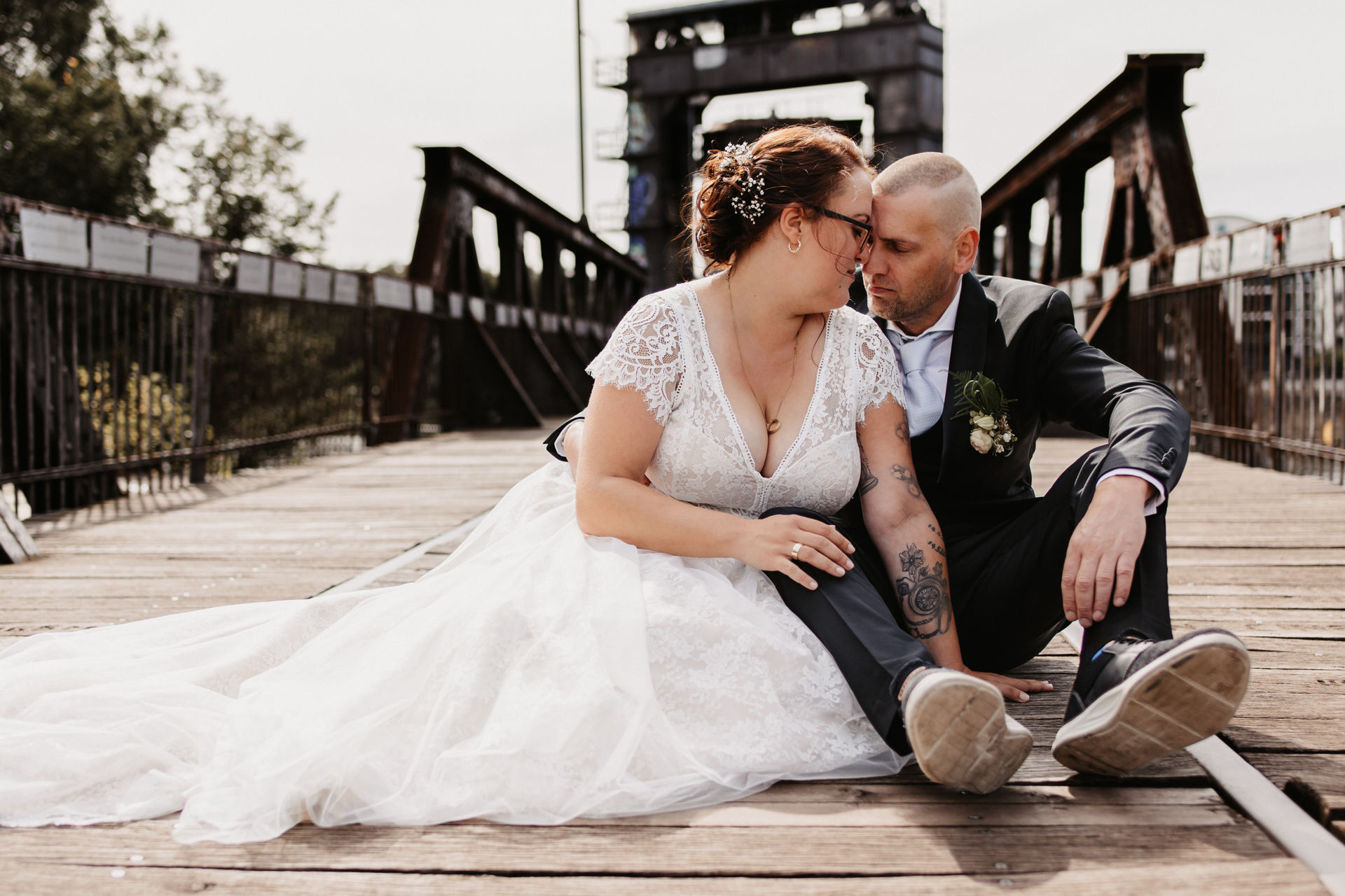 Brautpaar sitzt auf einer Holzbrücke im Urbanen Magdeburg an der Elbe